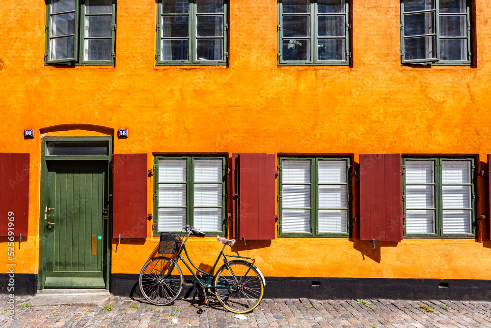 Street with yellow Danish house and a bike in Copenhagen, Denmark, Europe