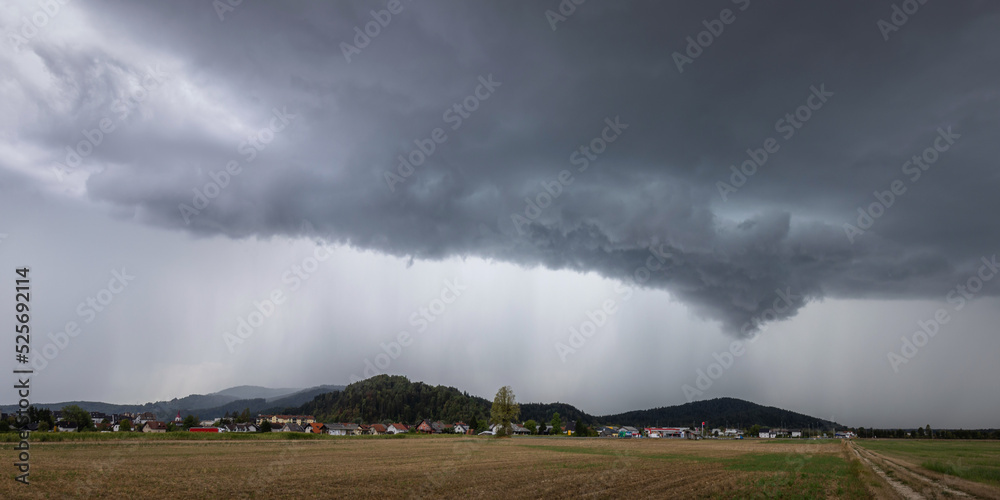 Destructive supercell storm bringing rain and wind over the farm field