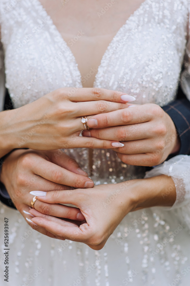 Wedding close-up portrait of the hands and fingers with golden rings of the bride and groom at an outdoor ceremony. Festive photo of newlyweds, idea. Wedding close-up portrait of the hands and fingers with golden rings of the bride and groom at an outdoor ceremony. Festive photo of newlyweds, idea.