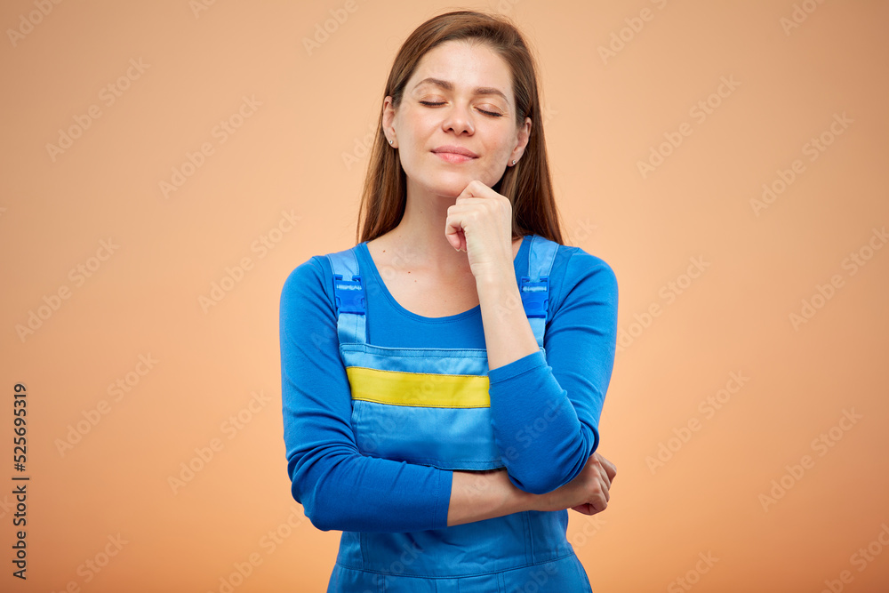 Builder woman worker in blue overalls. Isolated female portrait with eyes closed. Builder woman worker in blue overalls. Isolated female portrait with eyes closed.