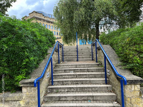 Fototapeta Naklejka Na Ścianę i Meble -  Steps with blue handrails, leading to, Oak Lane, with Victorian buildings in the distance near, Westbourne Green, Bradford, Uk