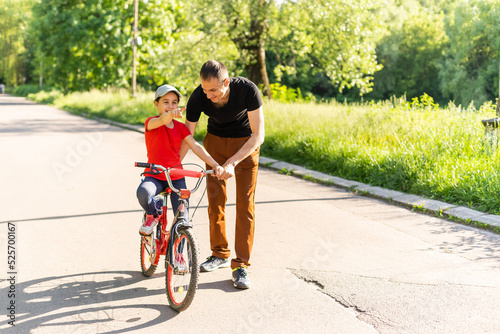happy father rejoices that her daughter learned to ride a bike