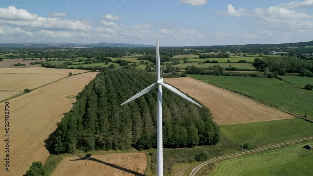 Aerial high to low level drop down clip of a wind turbine in a small rural wind farm in the English countryside Aerial high to low level drop down clip of a wind turbine in a small rural wind farm in the English countryside