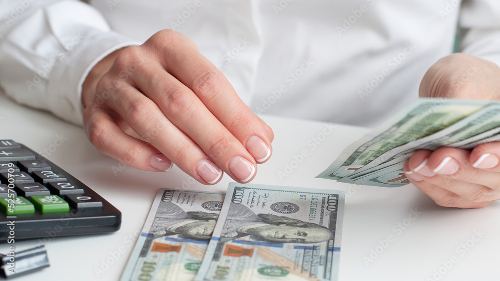 savings, finances, economy and home concept - close up of woman with calculator counting money and making notes at home savings, finances, economy and home concept - close up of woman with calculator counting money and making notes at home