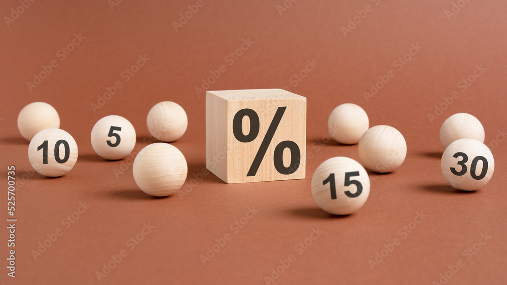 percent sign on wooden cubes against broun background with wooden balls. concept of sale and discount percent sign on wooden cubes against broun background with wooden balls. concept of sale and discount