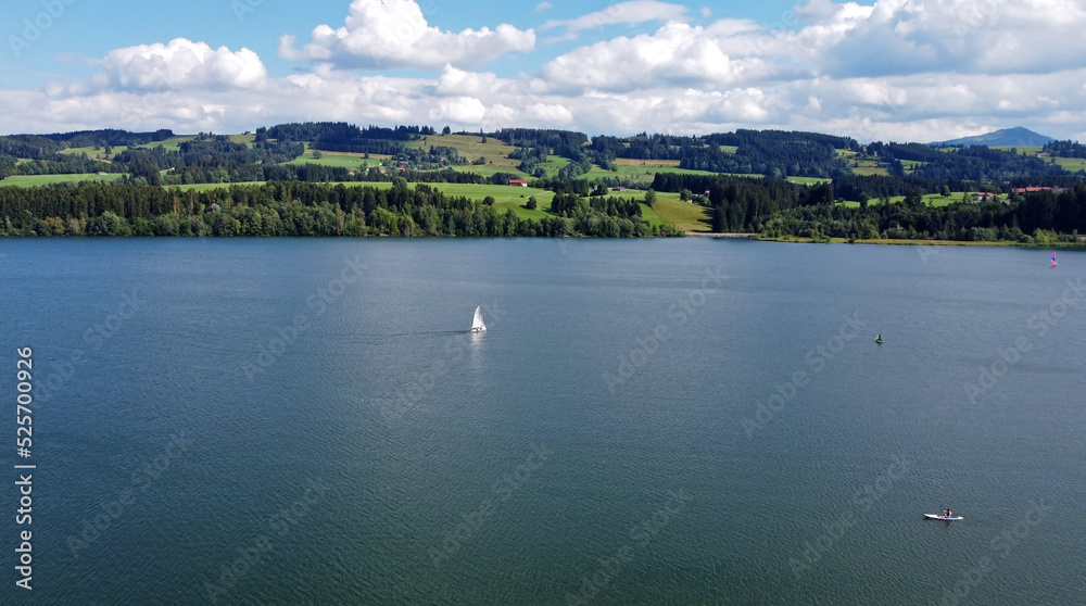 Luftaufnahme mit einer Drohne von einem See mit Segelbooten und Stand-Up-Paddler