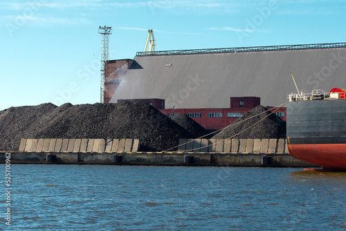 Loading coal on a cargo ship in the port. Sea cargo port, industrial background. photo