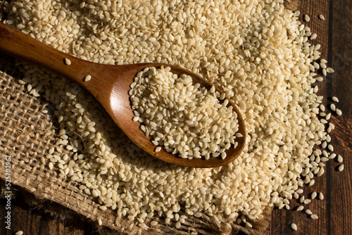 Sesame seeds spoon on old background