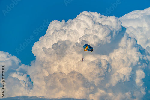 Parasailing over the sea, against the background of huge cumulus clouds.