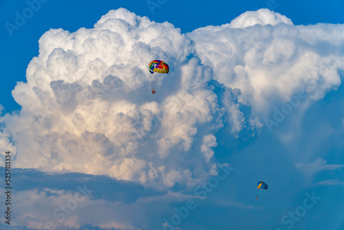 Parasailing over the sea, against the background of huge cumulus clouds.