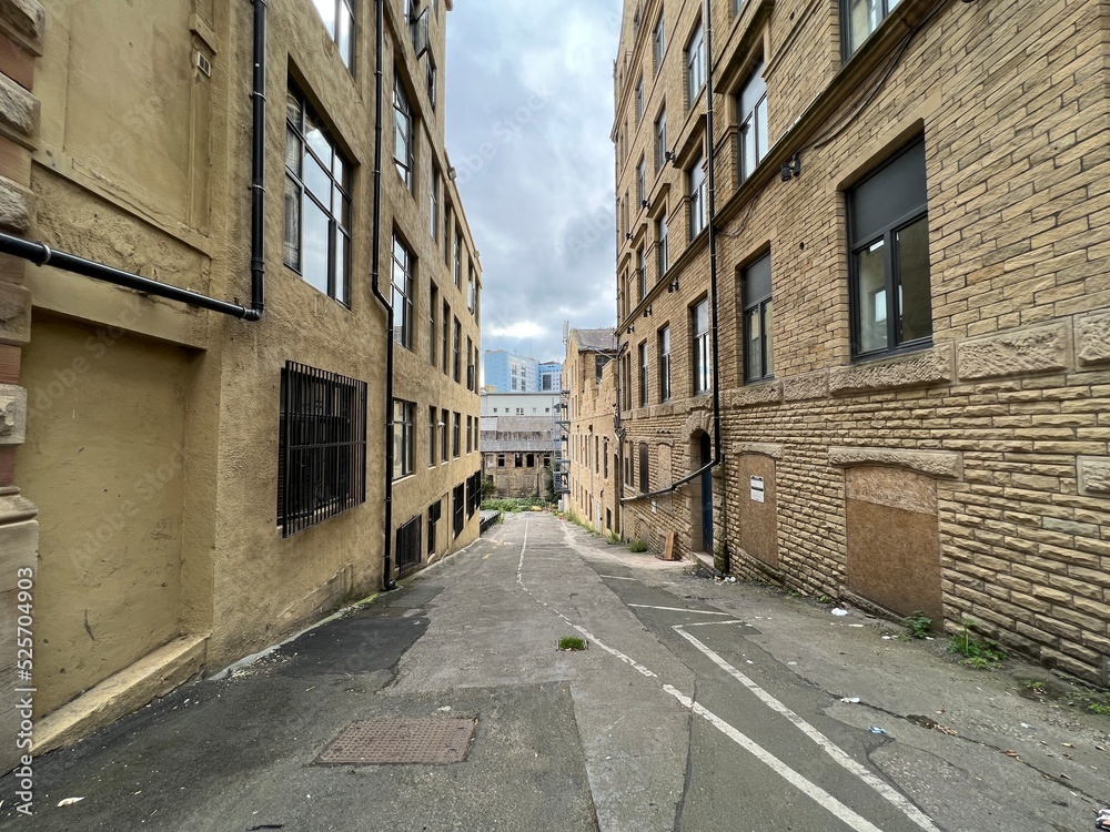View down, Greenaire Place, with former Victorian warehouses, a derelict mill, and university buildings in the distance in, Bradford, UK