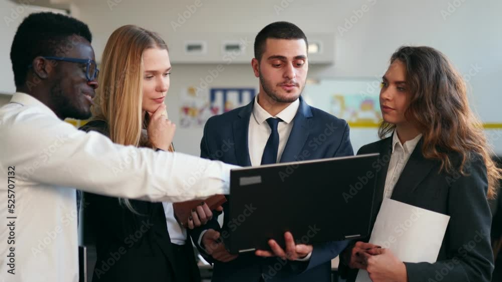 Businessman shows data for briefing on laptop. International business partners discuss project results on meeting in office. Multiethnic corporate team planning. People brainstorming on briefing. Businessman shows data for briefing on laptop. International business partners discuss project results on meeting in office. Multiethnic corporate team planning. People brainstorming on briefing.