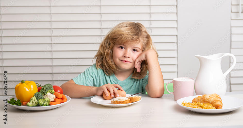 Schoolkid eating breakfast before school. Portrait of child sit at desk at home kitchen have delicious tasty nutritious breakfast. Schoolkid eating breakfast before school. Portrait of child sit at desk at home kitchen have delicious tasty nutritious breakfast.