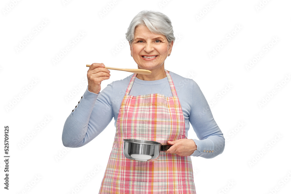 food cooking, culinary and old people concept - portrait of smiling senior woman in kitchen apron with pot and spoon over white background food cooking, culinary and old people concept - portrait of smiling senior woman in kitchen apron with pot and spoon over white background