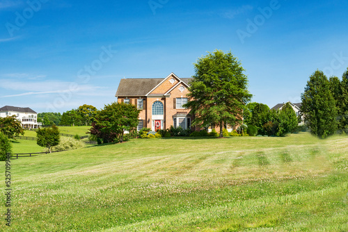 Landscape with a large country house. Large mowed lawn and blue sky. © kosoff
