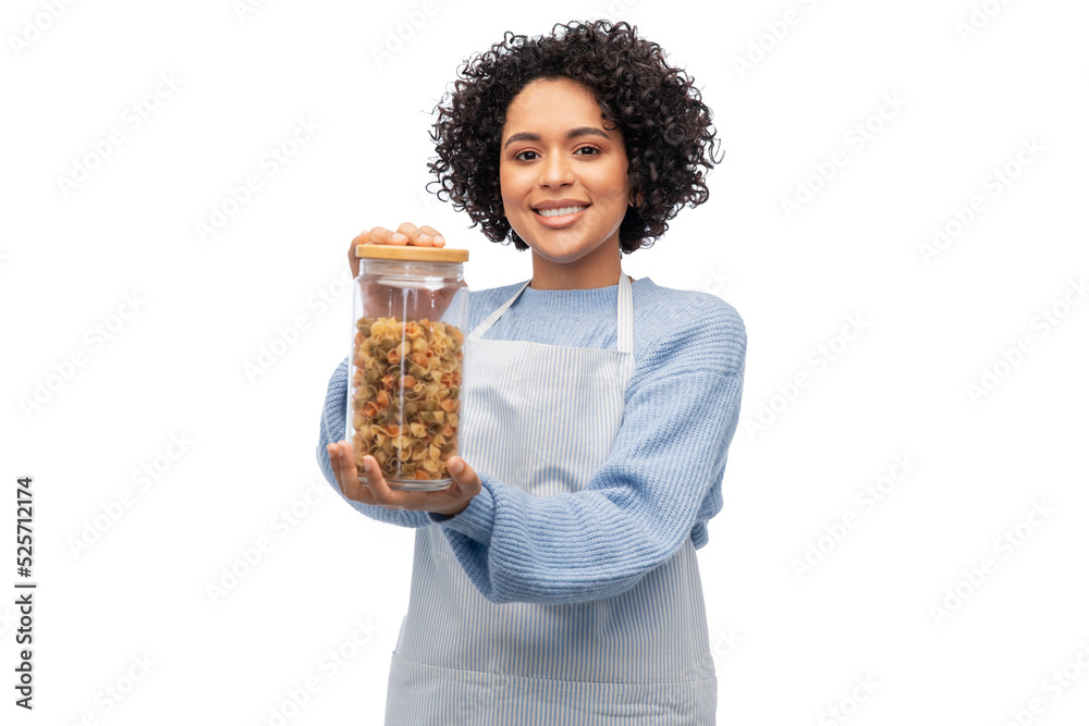 cooking, culinary and people concept - happy smiling woman in apron holding jar with pasta over white background cooking, culinary and people concept - happy smiling woman in apron holding jar with pasta over white background