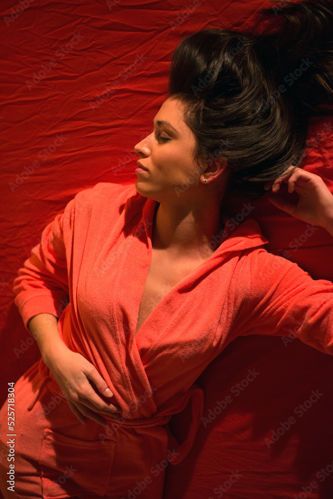 Fototapeta premium Young sexy woman in bathrobe lying on the bed with closed eyes