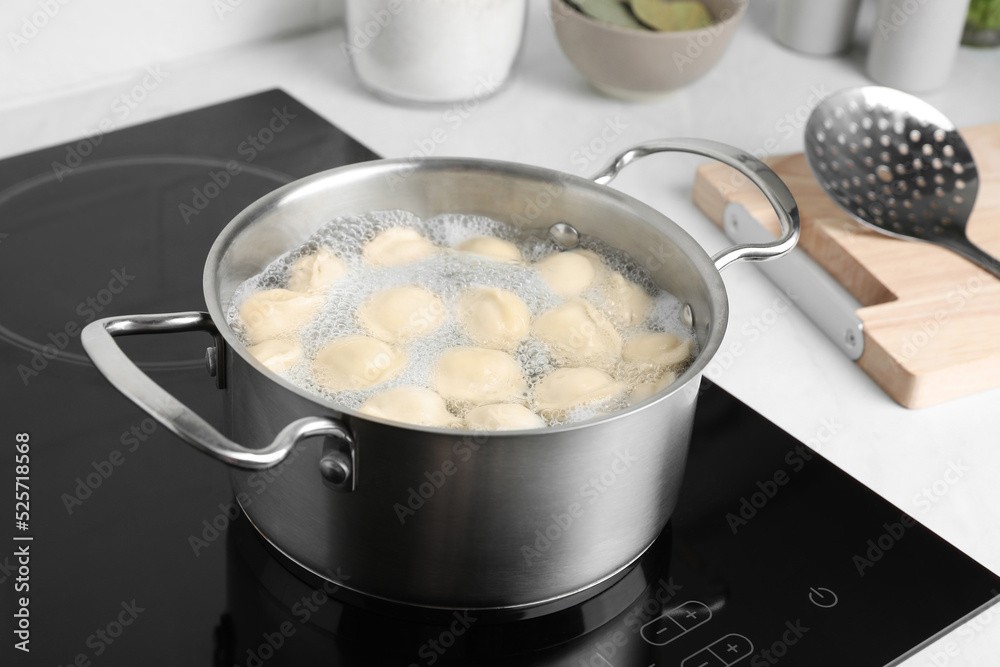 Cooking delicious dumplings in pot on cooktop Cooking delicious dumplings in pot on cooktop