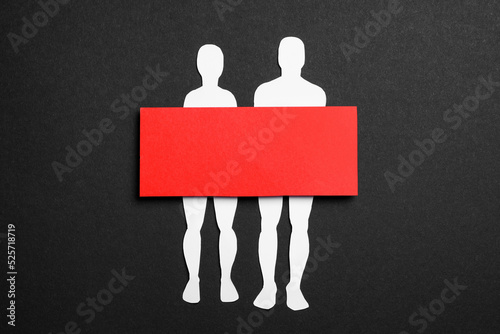 Couple figure cutout with censor bar on black background, top view