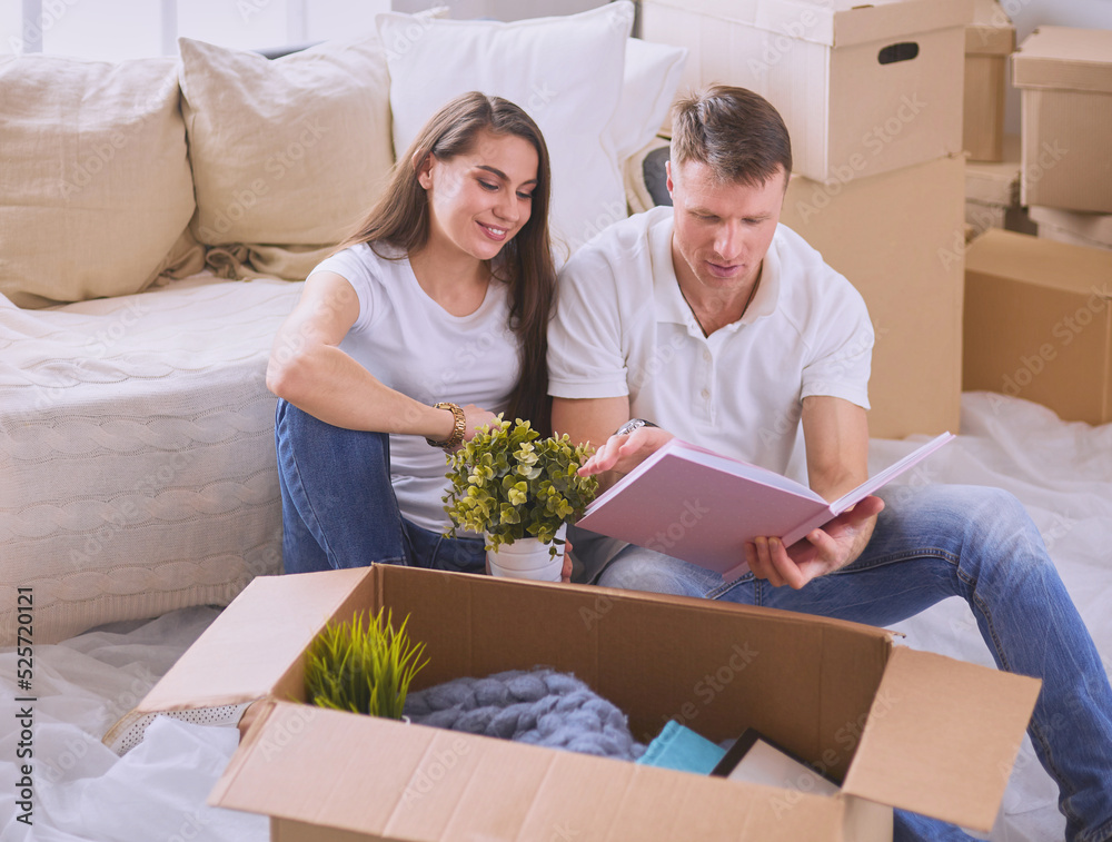 Cute couple unpacking cardboard boxes in their new home Cute couple unpacking cardboard boxes in their new home