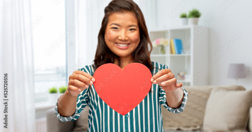 love, charity and valentine's day concept - happy woman with red heart over home background love, charity and valentine's day concept - happy woman with red heart over home background