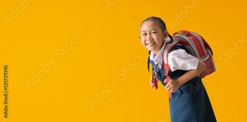Funny cute smiling schoolgirl in uniform, isolated on yellow background with Clipping paths for design work empty free space