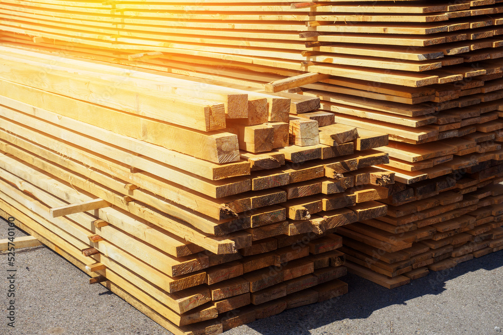 Wooden boards are stacked in a sawmill or carpentry shop. Sawing drying and marketing of wood. Industrial background Wooden boards are stacked in a sawmill or carpentry shop. Sawing drying and marketing of wood. Industrial background