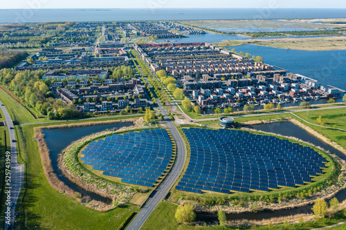 Modern sustainable neighbourhood in Almere, The Netherlands. The city heating (stadswarmte) in the district is partially powered by a solar panel island (Zoneiland). Aerial view.
