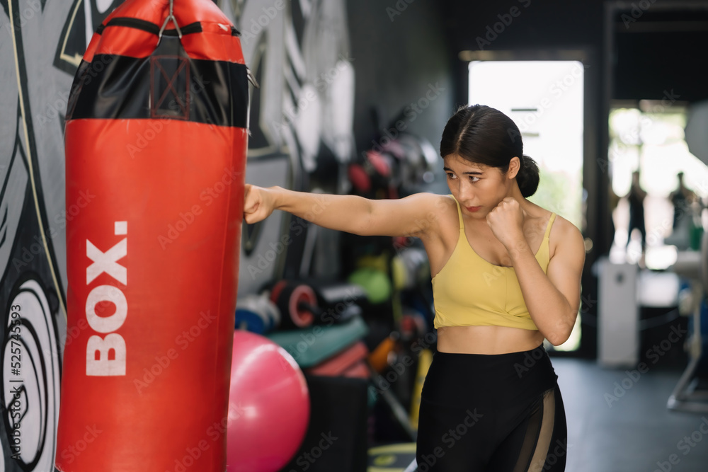Beautiful Asian woman in sporty workout clothes showing off her perfect figure. Exercise your body by boxing for a beautiful and strong figure.