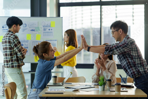 Young Asian business people working as a team meeting and work together on new project emphasizing unity and teamwork.