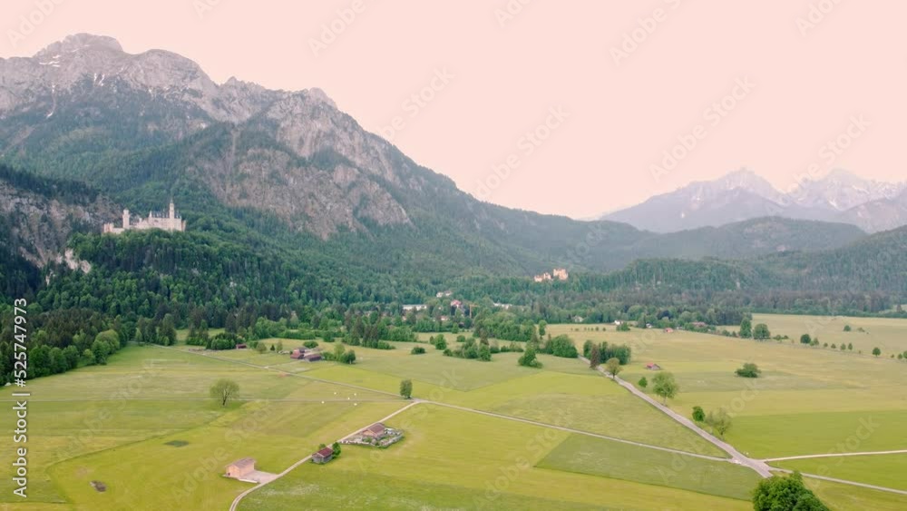 Farmland flyover at Neuschwanstein Castle near Fussen in southwest Bavaria, Germany. Historic palace near the Alps, surrounded by forest, mountains, and wide plains - 4K 30fps Smooth Tracking Left Farmland flyover at Neuschwanstein Castle near Fussen in southwest Bavaria, Germany. Historic palace near the Alps, surrounded by forest, mountains, and wide plains - 4K 30fps Smooth Tracking Left