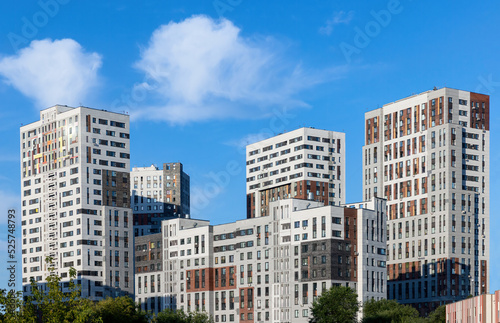 Monolithic residential apartment block buildings district on blue sky