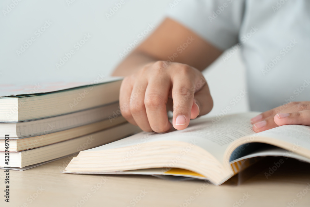Literacy and education concept woman reading book and book stack on desk Literacy and education concept woman reading book and book stack on desk