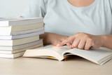 Literacy and education concept woman reading book and book stack on desk