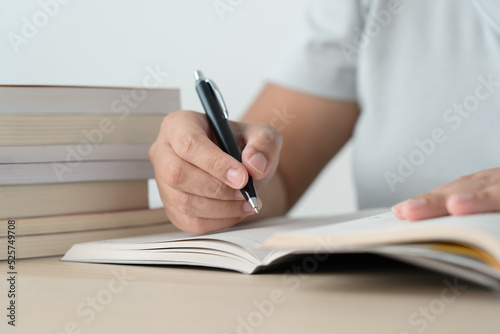 Literacy and education concept woman reading book and book stack on desk