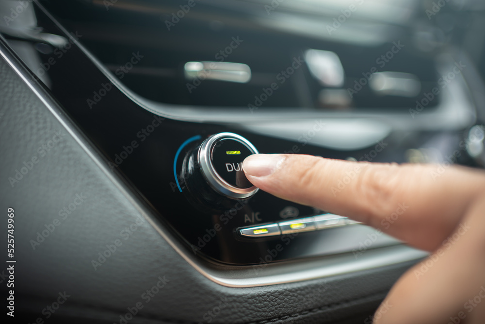 Naklejka premium Driver adjusting car air conditioner system at interior panel