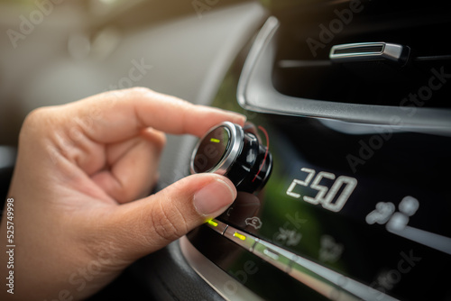 Driver adjusting car air conditioner system at interior panel