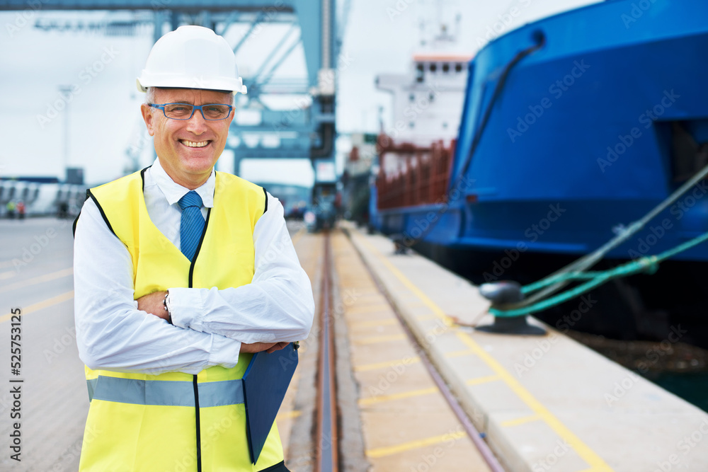 Industrial worker working on a shipping port to export stock, containers and packages. Portrait of logistics, business and industry employee with a crane at a cargo freight warehouse dock.