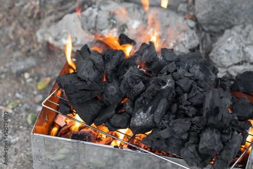 Burning coals inside a barbecue - blurred background