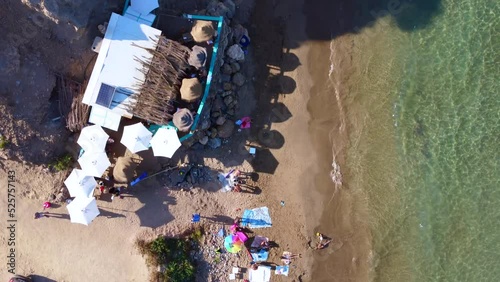 hippie bar with umbrellas on nudist beach.
Great aerial view flight bird's eye view drone footage vertical 9:16 of Aigües Blanques beach Ibiza summer day july 2022. P. Marnitz 4k Cinematic from above photo
