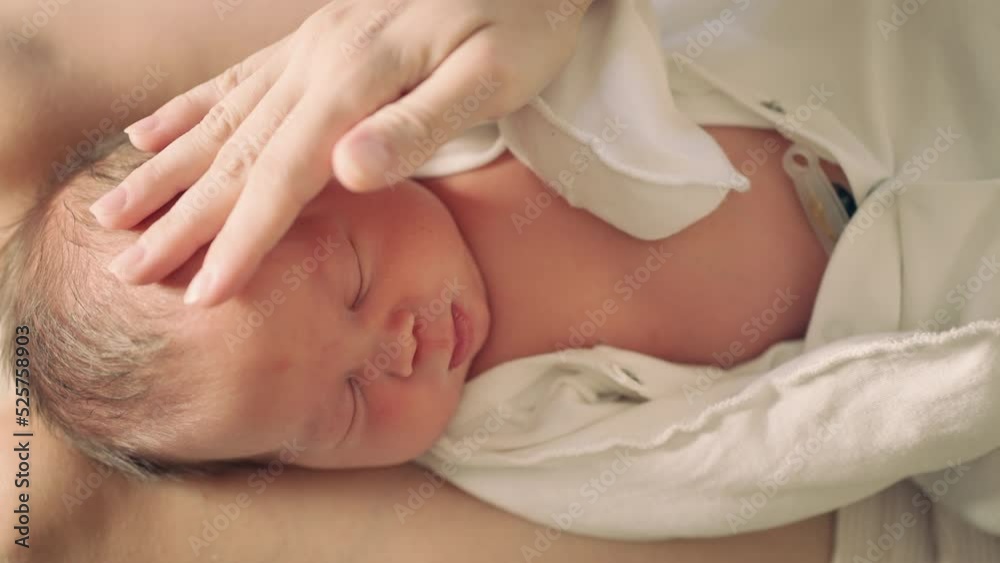 newborn baby close-up with mother's hand that gently touches the baby newborn baby close-up with mother's hand that gently touches the baby