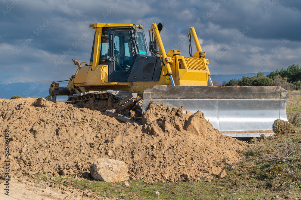 Obraz premium Excavator moving dirt and sand at a construction site