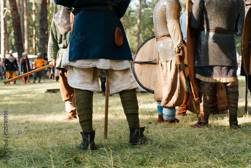 Medieval soldiers preparing for battle on the battlefield, outdoor historical reenactment festival. Close-up of legs, low angle view