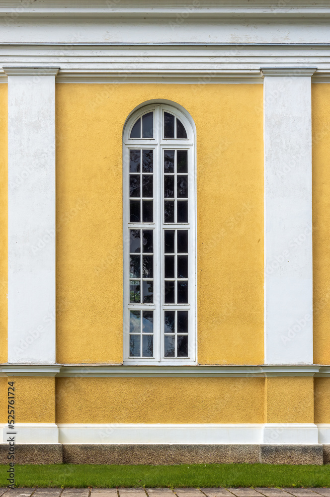 Fototapeta premium Facade of yellow wall architecture with arched window and columns