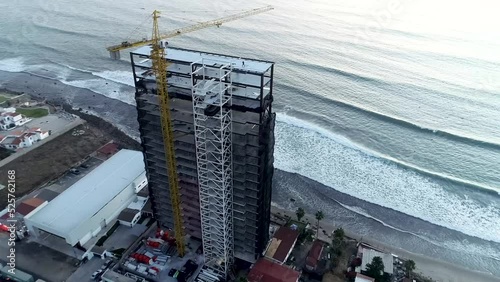 Drone flying over an under construction building in front of the sea coast photo