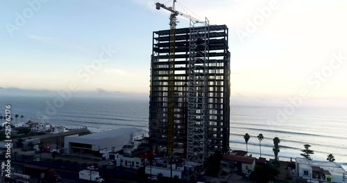 Drone flying around an under construction building in front of the sea coast photo