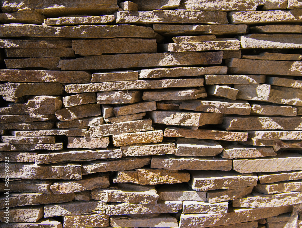 Texture of uneven bricks. The old wall. Bright sunlight and deep shadows. Abstract background. Texture of uneven bricks. The old wall. Bright sunlight and deep shadows. Abstract background.