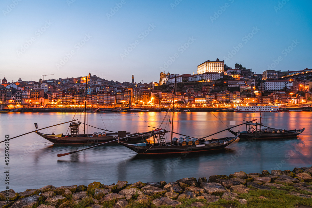 Evening on the Douro River in Porto. View of the illuminated old town. Boats in the foreground. Portugal