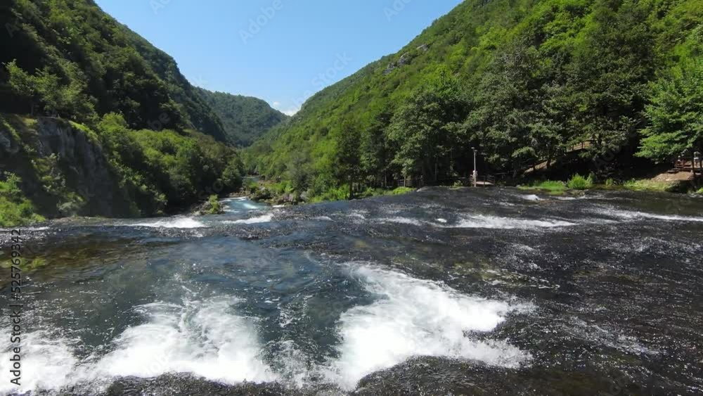 Fast extreme dive flight over the epic waterfall at exotic Una river aerial view. FPV sport drone speed movement nature at vegetation greenery wild environment Fast extreme dive flight over the epic waterfall at exotic Una river aerial view. FPV sport drone speed movement nature at vegetation greenery wild environment