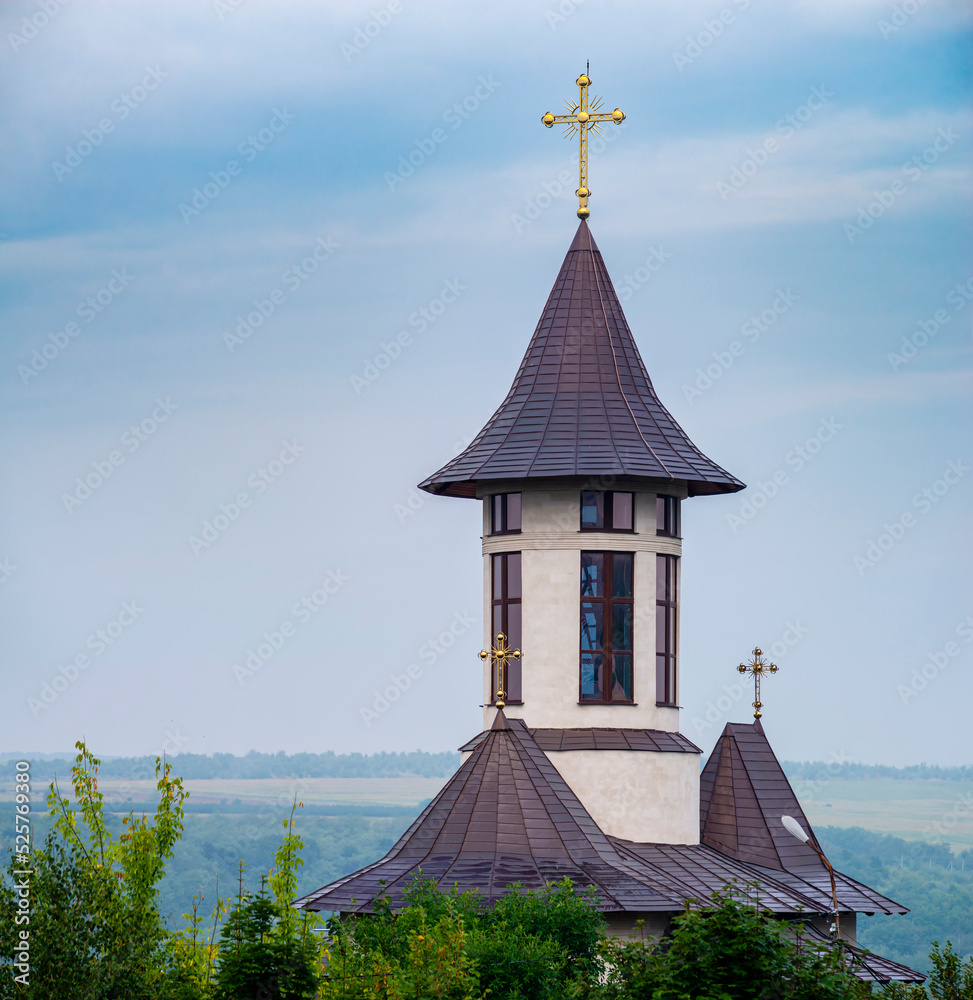 church bell tower in the blue sky sharp pointed steeple on a brick church gold cross landscape tree summer Orthodox. church bell tower in the blue sky sharp pointed steeple on a brick church gold cross landscape tree summer Orthodox.